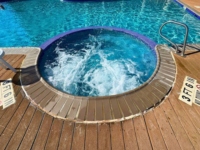 view of swimming pool with an in ground hot tub