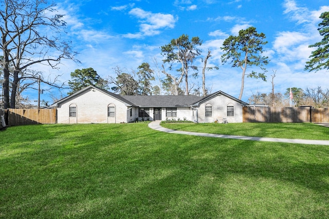 ranch-style house featuring fence private yard and a front lawn