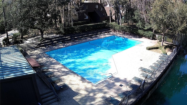 community pool with a patio and a water view