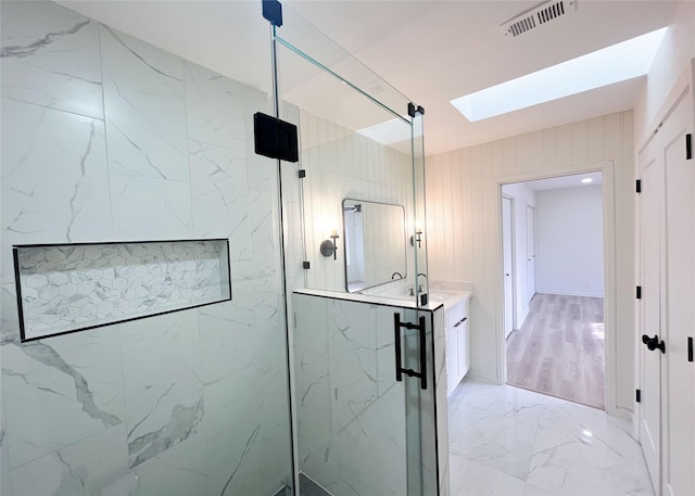 bathroom with vanity, visible vents, a marble finish shower, a skylight, and marble finish floor