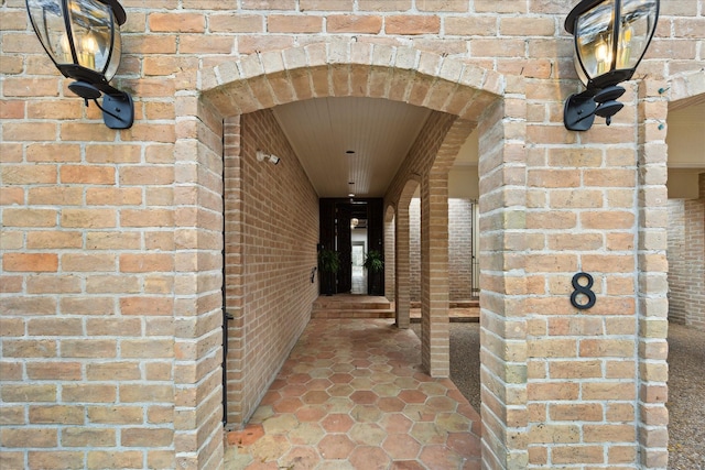 view of exterior entry featuring brick siding
