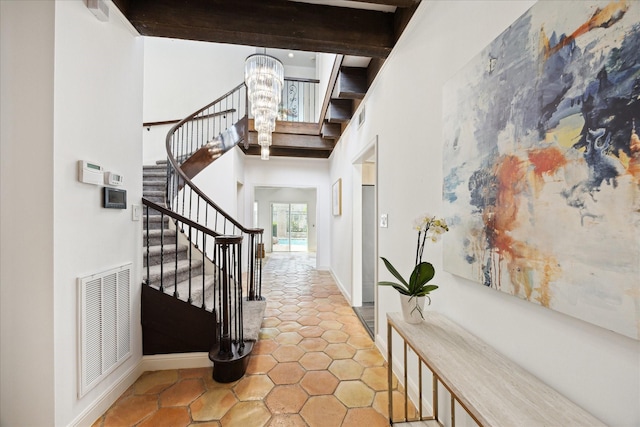 entryway featuring visible vents, beam ceiling, stairs, a towering ceiling, and a chandelier