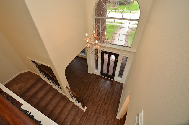 foyer with visible vents, a towering ceiling, stairway, wood finished floors, and a chandelier