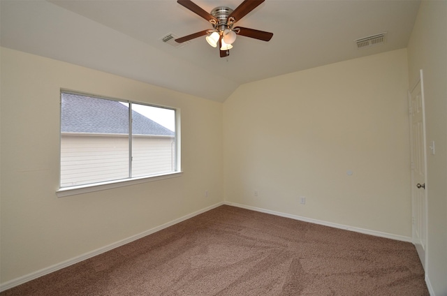 carpeted empty room featuring vaulted ceiling, ceiling fan, visible vents, and baseboards