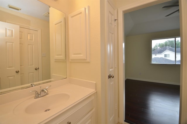 bathroom featuring visible vents, vanity, baseboards, and wood finished floors