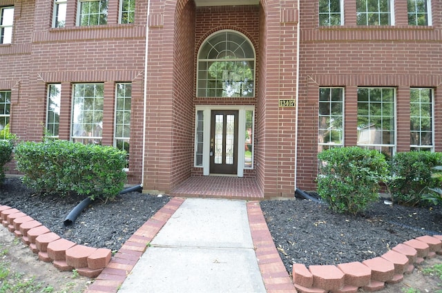 doorway to property featuring brick siding