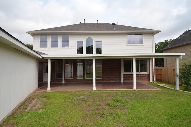 rear view of house featuring brick siding, a lawn, a patio area, and fence