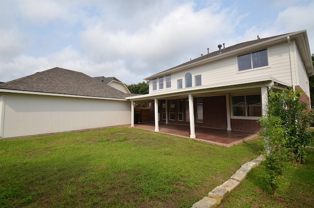 rear view of house featuring brick siding, a lawn, and a patio