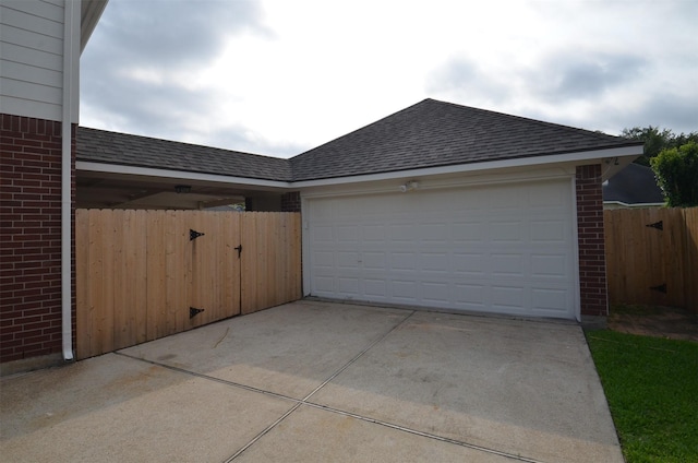 garage featuring fence and driveway