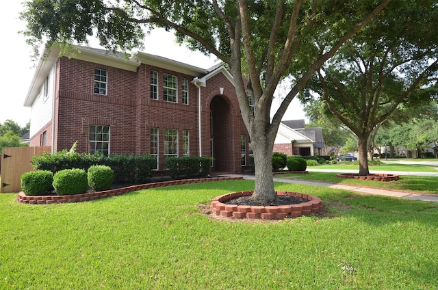 traditional home with a front yard and brick siding