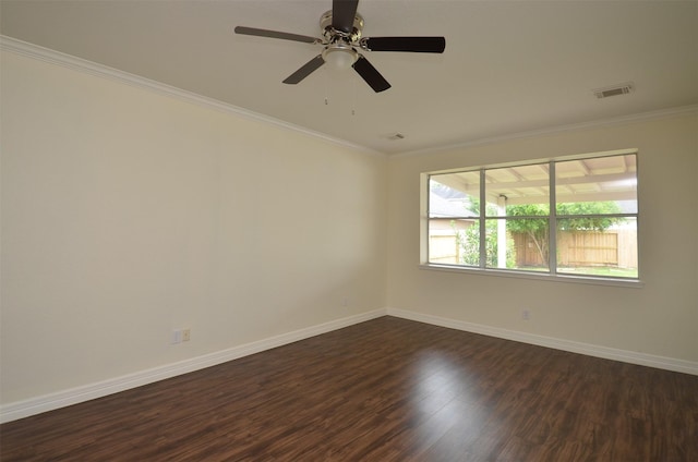 empty room with ornamental molding, visible vents, dark wood finished floors, and baseboards