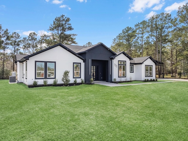 modern farmhouse style home with stucco siding, a front lawn, and central air condition unit