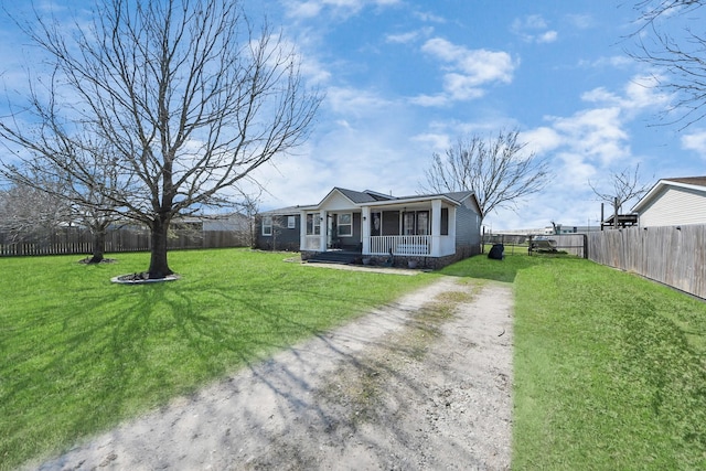 view of front of property with a front yard, covered porch, a fenced backyard, and dirt driveway