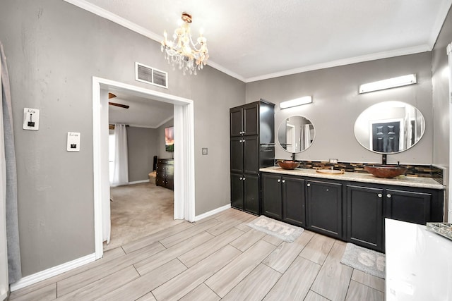 full bath featuring ornamental molding, visible vents, a sink, and baseboards