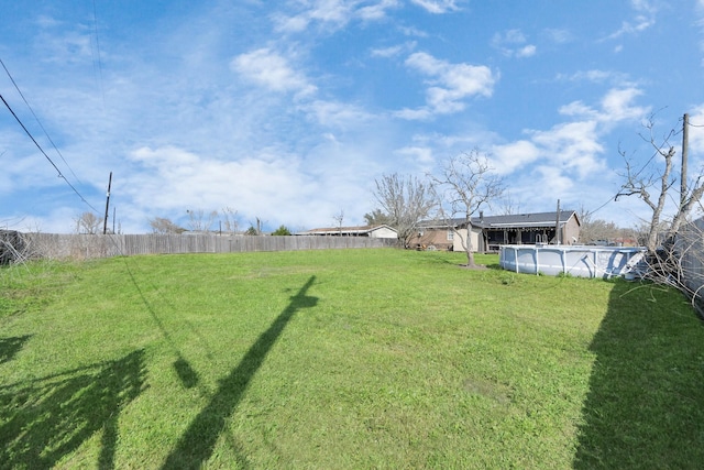 view of yard featuring fence and a fenced in pool