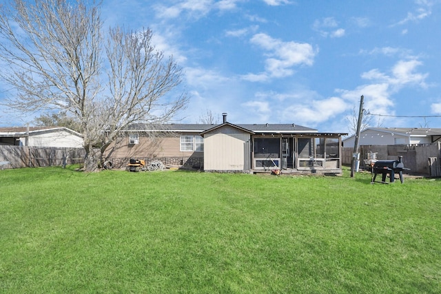 rear view of property with a fenced backyard and a lawn