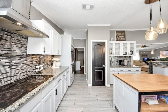 kitchen featuring visible vents, wooden counters, white cabinets, ceiling fan, and under cabinet range hood