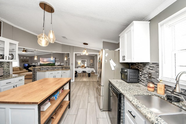 kitchen with white cabinets, dishwasher, a ceiling fan, butcher block countertops, and a sink