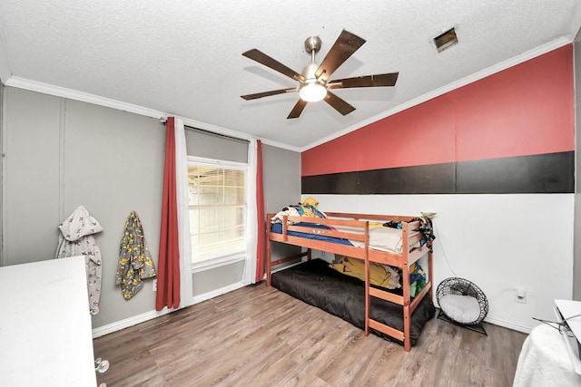 bedroom featuring ornamental molding, vaulted ceiling, and wood finished floors