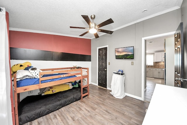 bedroom with ornamental molding, a textured ceiling, and wood finished floors