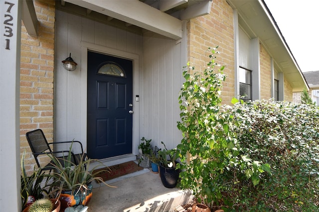 entrance to property featuring brick siding