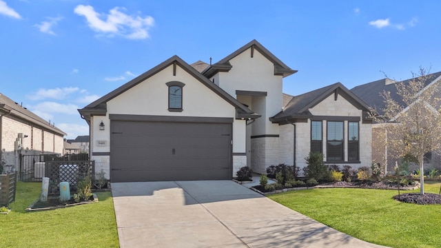 french country inspired facade with a front yard, stucco siding, concrete driveway, a garage, and stone siding