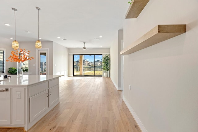 kitchen featuring recessed lighting, hanging light fixtures, light countertops, white cabinetry, and light wood-type flooring