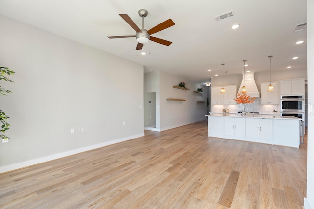 unfurnished living room with visible vents, recessed lighting, light wood finished floors, baseboards, and ceiling fan