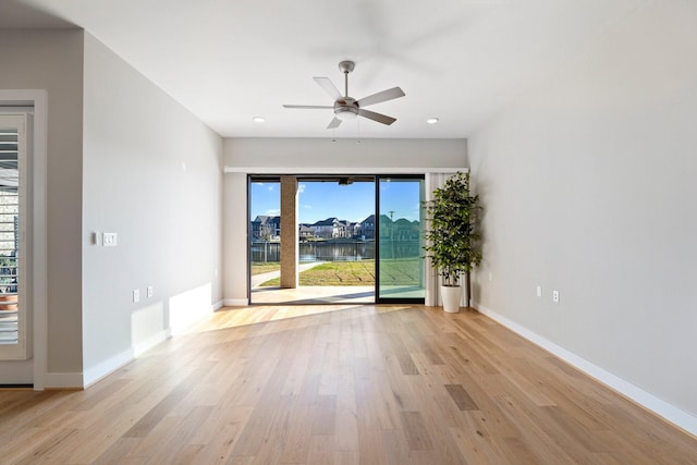 empty room featuring baseboards, a ceiling fan, and light wood finished floors