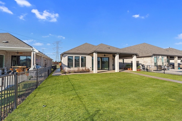 rear view of property with brick siding, a lawn, a fenced backyard, a ceiling fan, and a patio