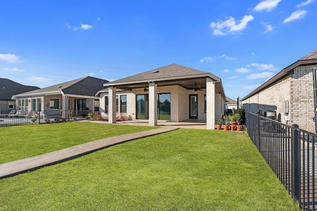 rear view of property featuring a ceiling fan, a patio area, a yard, and a fenced backyard