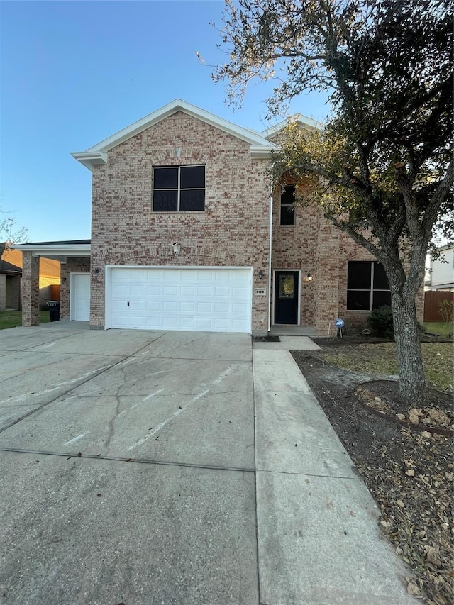 traditional home with driveway, brick siding, and an attached garage