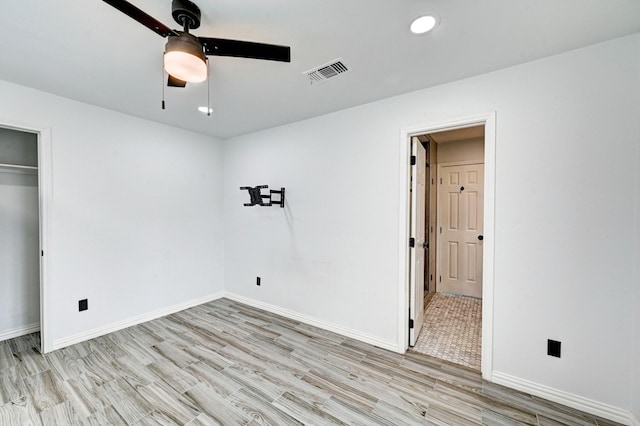 unfurnished bedroom with baseboards, a ceiling fan, visible vents, and light wood-style floors