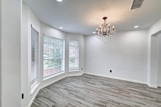 unfurnished room featuring a notable chandelier, recessed lighting, visible vents, wood finished floors, and baseboards