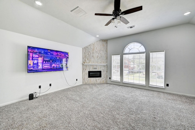 unfurnished living room with lofted ceiling, a large fireplace, visible vents, and carpet