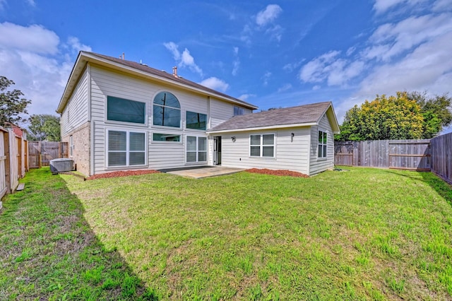 back of property featuring brick siding, a lawn, a patio area, cooling unit, and a fenced backyard