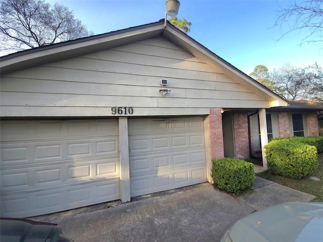 garage featuring concrete driveway