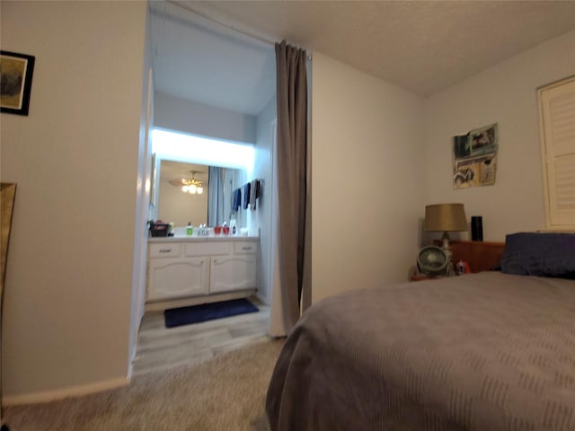 bedroom featuring baseboards and ensuite bathroom