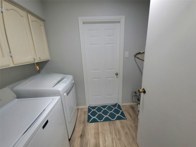 laundry room with baseboards, cabinet space, independent washer and dryer, and light wood-type flooring