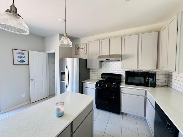 kitchen with decorative light fixtures, light tile patterned floors, tasteful backsplash, under cabinet range hood, and black appliances