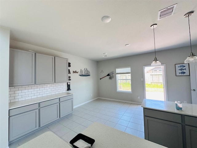 kitchen featuring tasteful backsplash, visible vents, gray cabinets, and light countertops