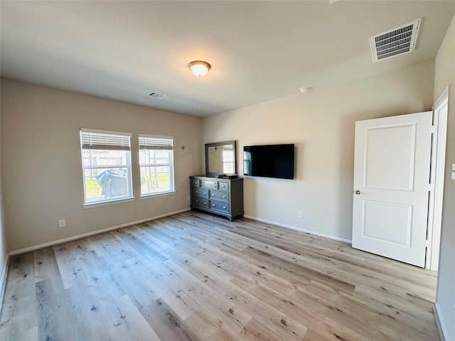 interior space featuring light wood-type flooring, visible vents, and baseboards