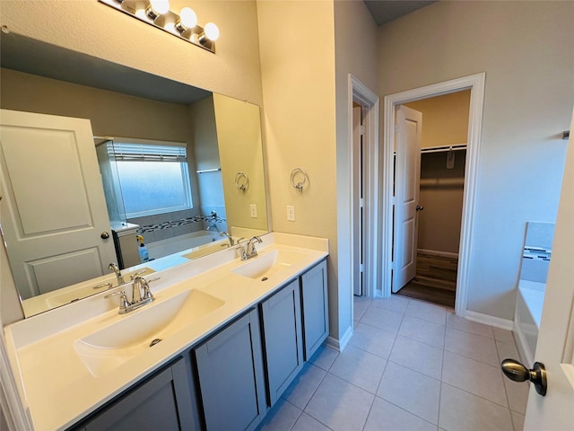 full bathroom with double vanity, tile patterned flooring, a bathing tub, and a sink