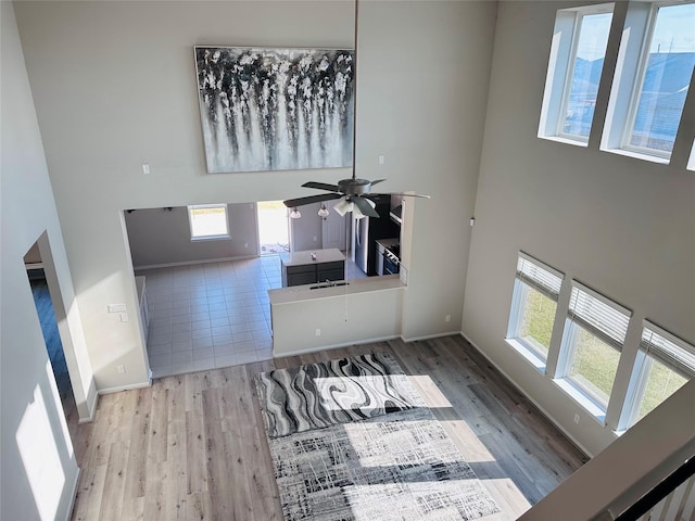 unfurnished living room featuring a healthy amount of sunlight, a high ceiling, and wood finished floors