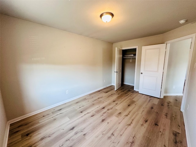 unfurnished bedroom featuring baseboards, a closet, and light wood-style floors