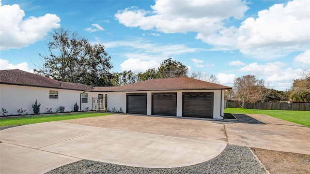 ranch-style home with driveway, a front lawn, an attached garage, and fence