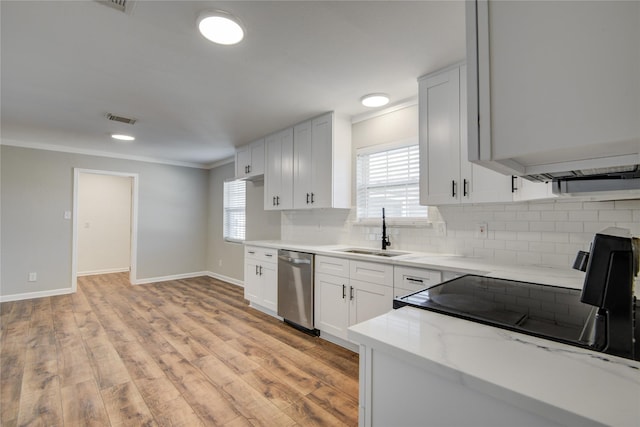 kitchen featuring light wood finished floors, visible vents, dishwasher, backsplash, and a sink