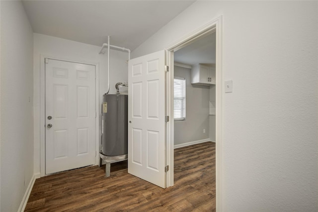 washroom with dark wood-style floors, water heater, and baseboards