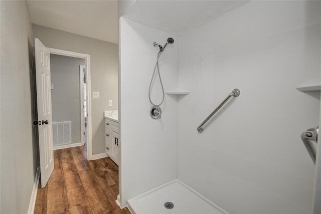 bathroom featuring a shower stall, visible vents, wood finished floors, and vanity