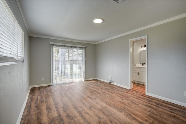 unfurnished room with baseboards, ornamental molding, and wood finished floors